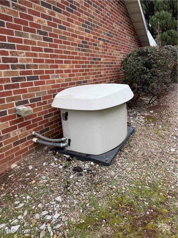 exterior details featuring brick siding and a power unit