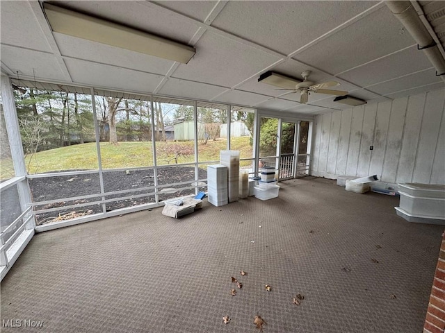 unfurnished sunroom featuring a paneled ceiling and ceiling fan