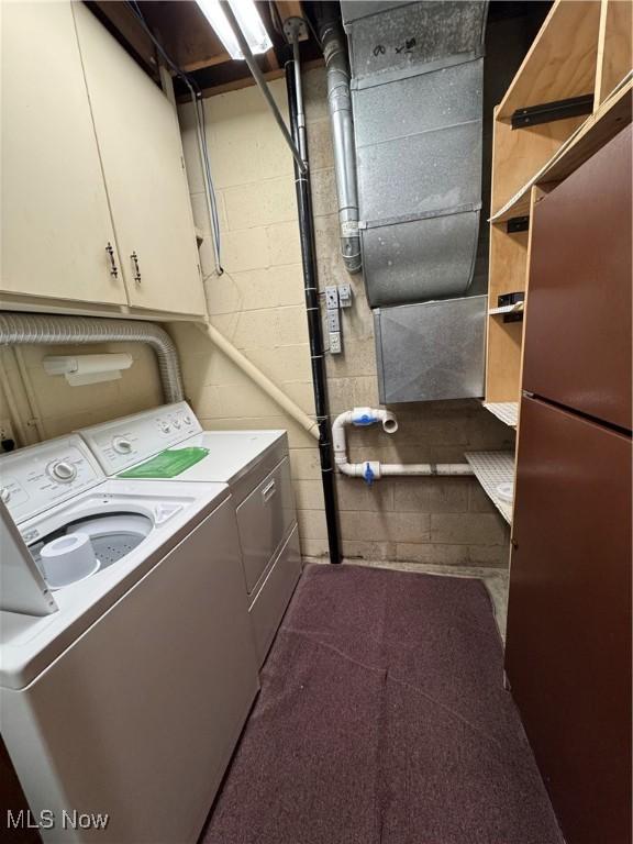 clothes washing area with cabinet space and washer and clothes dryer