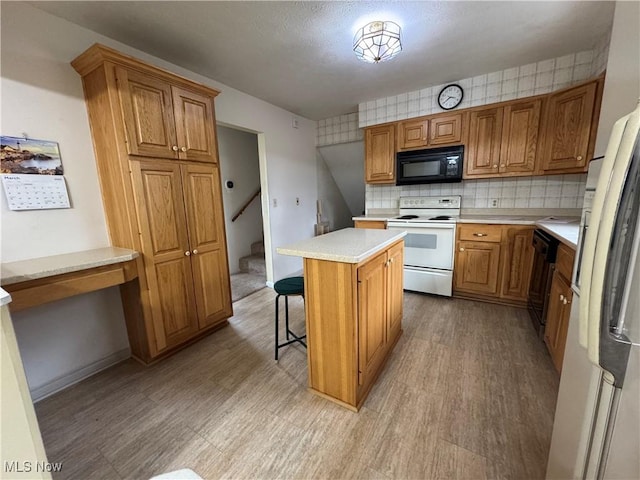 kitchen featuring light countertops, brown cabinetry, light wood-style floors, a kitchen island, and white appliances