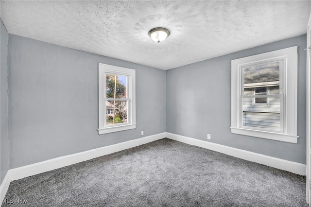 carpeted empty room featuring a textured ceiling