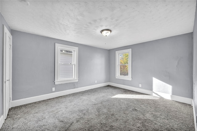 carpeted empty room with a textured ceiling