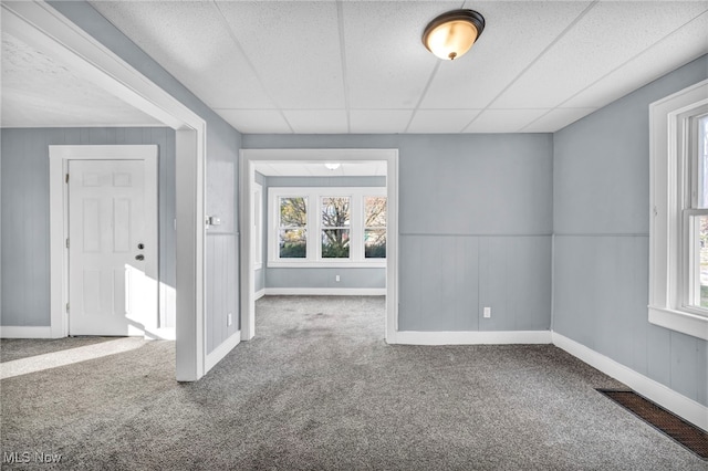 carpeted spare room featuring a healthy amount of sunlight and a paneled ceiling