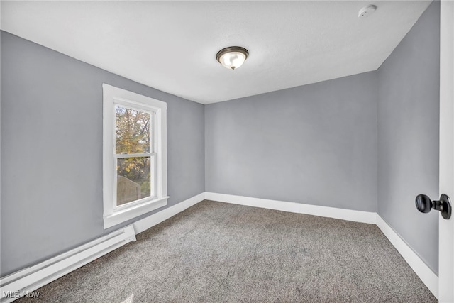 spare room featuring a baseboard heating unit and carpet flooring