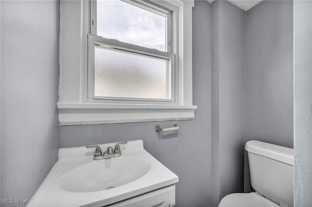 bathroom with sink, a wealth of natural light, and toilet