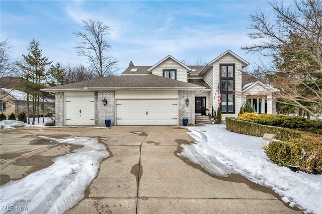 view of front of house with a shingled roof, brick siding, driveway, and an attached garage