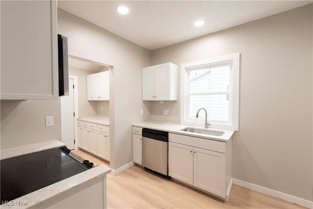 kitchen with dishwasher, sink, white cabinets, stove, and light hardwood / wood-style floors