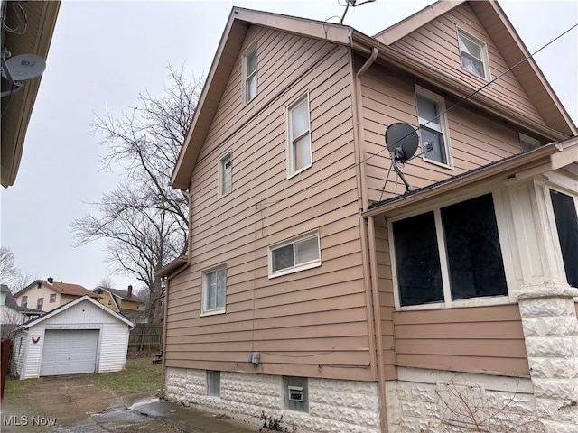 view of property exterior featuring a garage and an outdoor structure