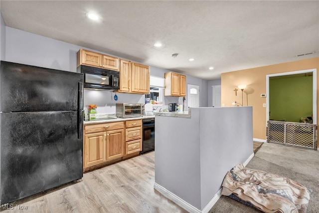 kitchen featuring light wood-type flooring, light brown cabinets, and black appliances