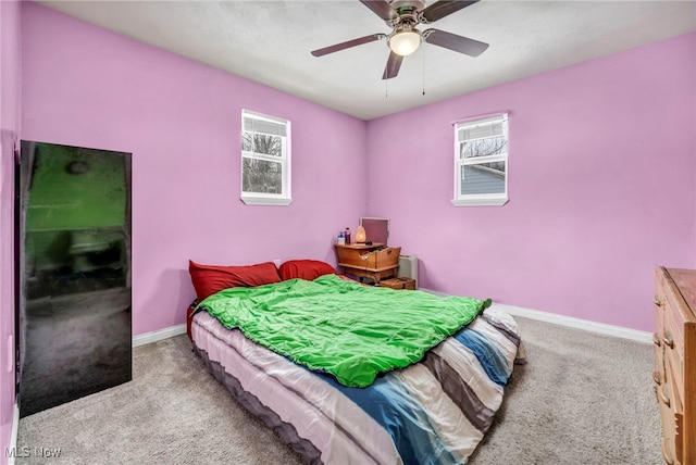 carpeted bedroom featuring multiple windows and ceiling fan