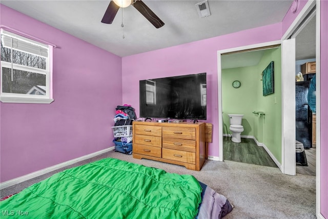 bedroom with ceiling fan, ensuite bathroom, and carpet floors