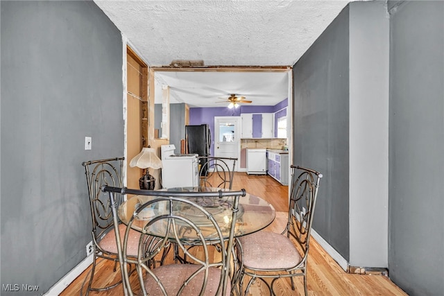 dining room with ceiling fan, light hardwood / wood-style floors, and a textured ceiling