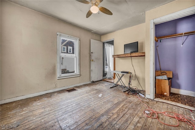 unfurnished bedroom with wood-type flooring, ceiling fan, and a closet