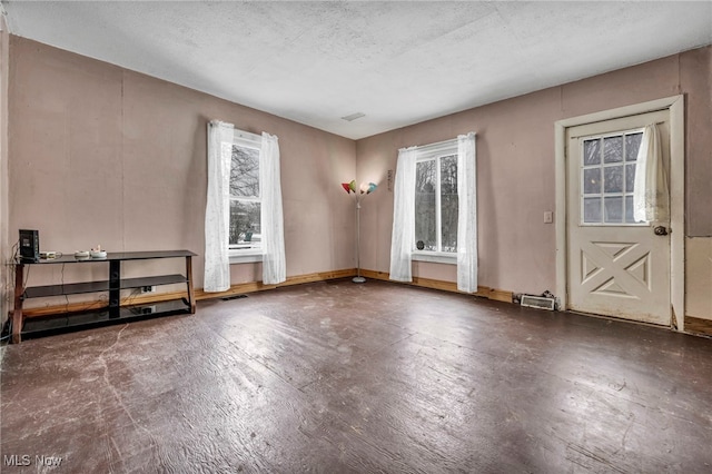 empty room with plenty of natural light and a textured ceiling