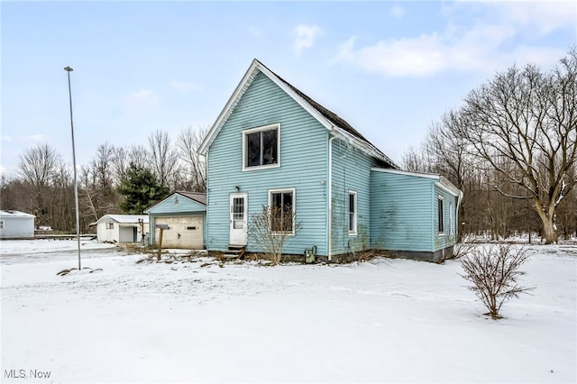 snow covered house featuring a garage