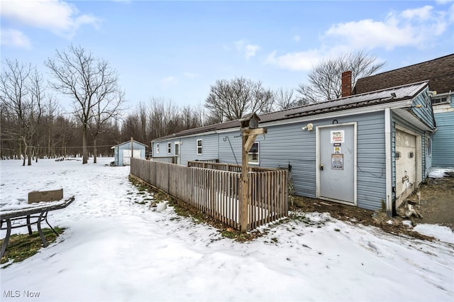 snow covered rear of property with a garage