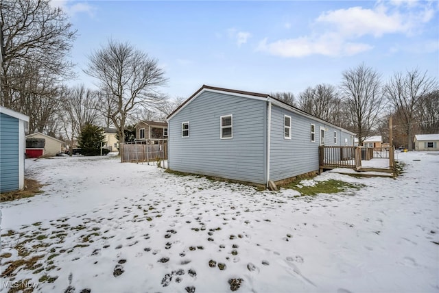 snow covered property with a wooden deck