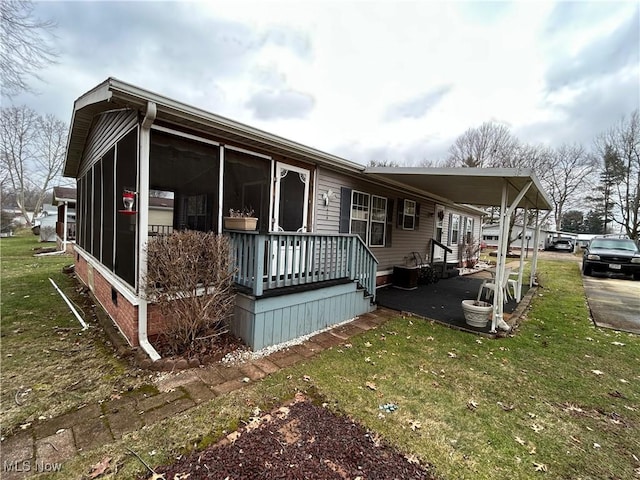 view of side of property featuring a yard and a sunroom