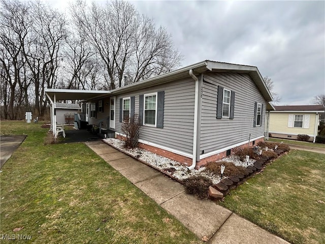 manufactured / mobile home with a front lawn and a carport