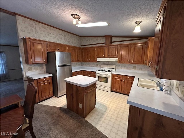 kitchen featuring a kitchen island, stainless steel refrigerator, white gas range, sink, and ornamental molding