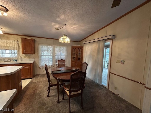 carpeted dining area with sink, crown molding, vaulted ceiling, and a textured ceiling