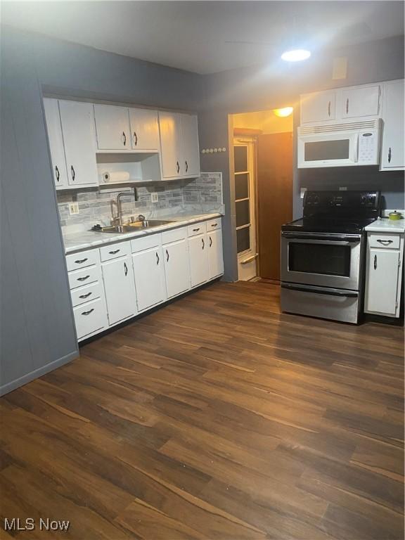 kitchen with sink, white cabinetry, dark hardwood / wood-style floors, stainless steel electric stove, and backsplash