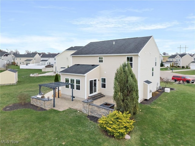 rear view of house featuring a patio, a pergola, and a lawn