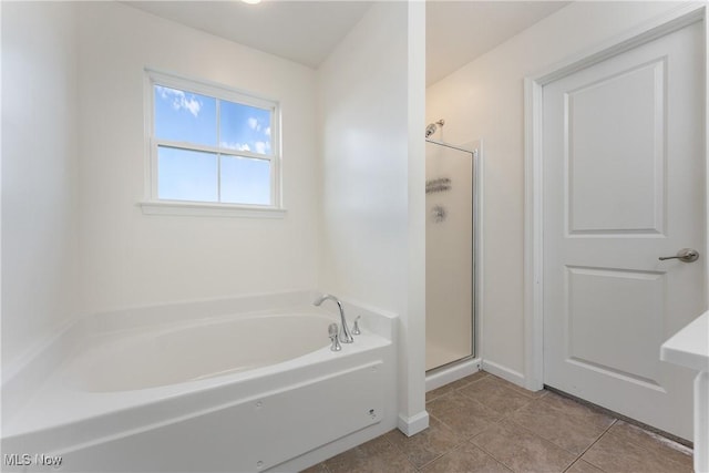 bathroom with tile patterned floors and shower with separate bathtub