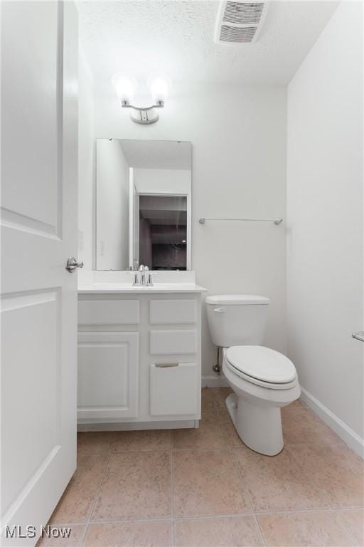 bathroom with tile patterned flooring, vanity, and toilet