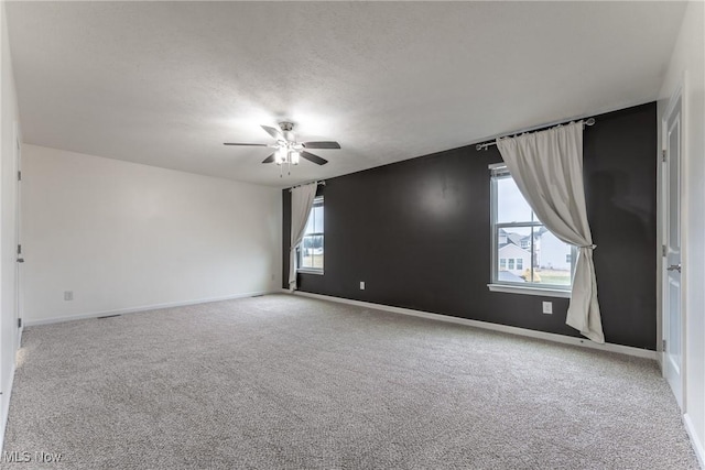 carpeted spare room with a textured ceiling and ceiling fan