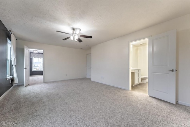 spare room with ceiling fan, light colored carpet, and a textured ceiling