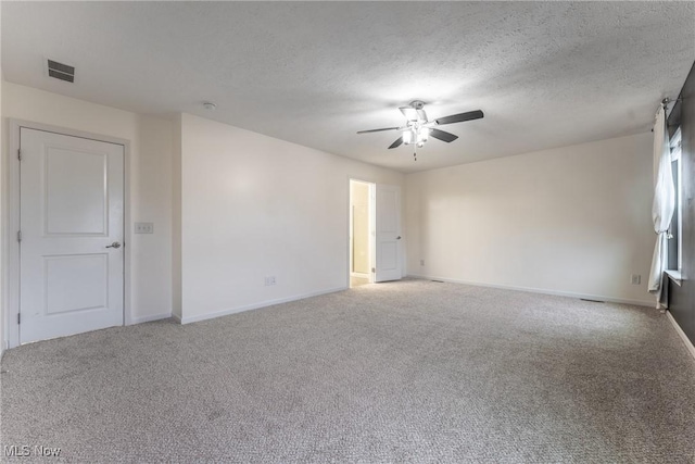 empty room with ceiling fan, carpet floors, and a textured ceiling