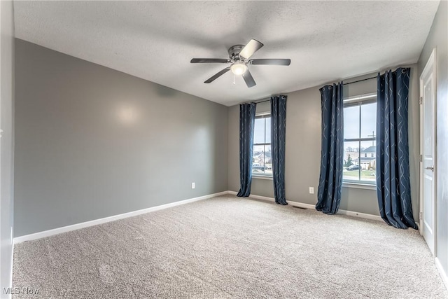 carpeted empty room featuring a textured ceiling and ceiling fan