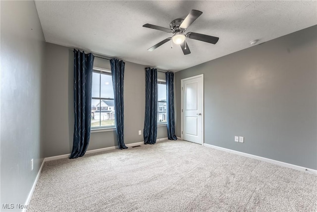 carpeted empty room featuring ceiling fan and a textured ceiling