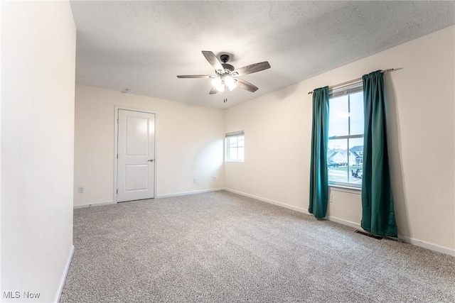 carpeted empty room with ceiling fan and a textured ceiling