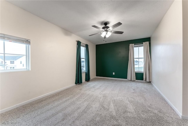 spare room featuring ceiling fan and carpet