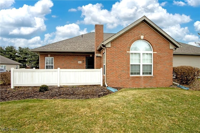 rear view of house featuring a yard