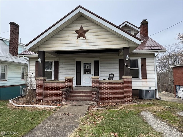 bungalow-style house with central AC, a front yard, and covered porch