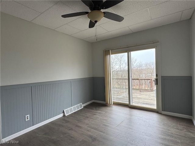 419 Saint Clair Ave, Cadiz, OH 43907 - spare room with wood finished floors, a paneled ceiling, a wainscoted wall, and ceiling fan