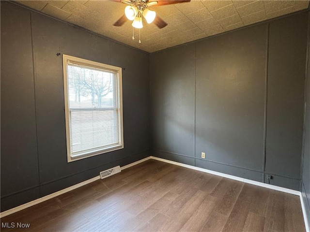 419 Saint Clair Ave, Cadiz, OH 43907 - spare room featuring dark wood finished floors, a decorative wall, a ceiling fan, and baseboards
