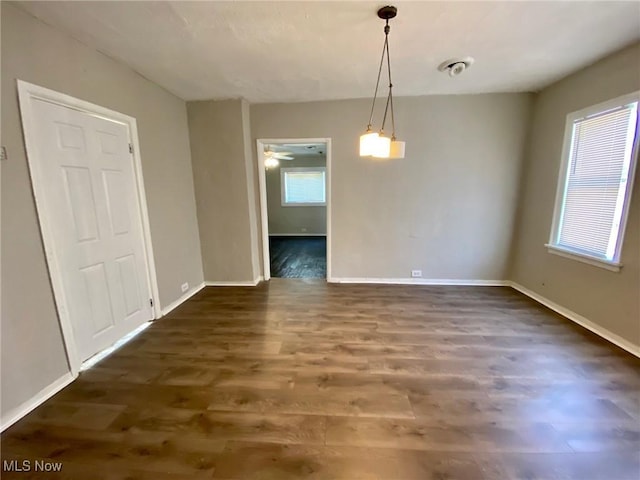 unfurnished dining area featuring ceiling fan, dark hardwood / wood-style flooring, and a wealth of natural light