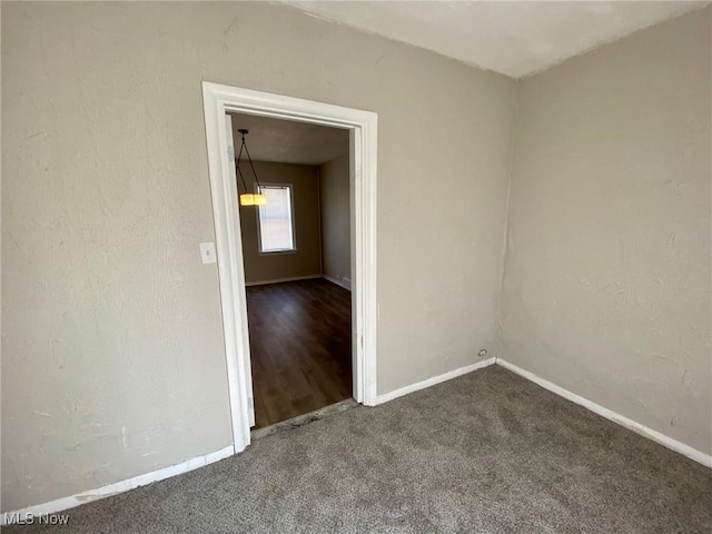 spare room featuring dark carpet