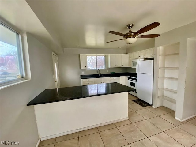 kitchen featuring light tile patterned flooring, sink, ceiling fan, white appliances, and white cabinets