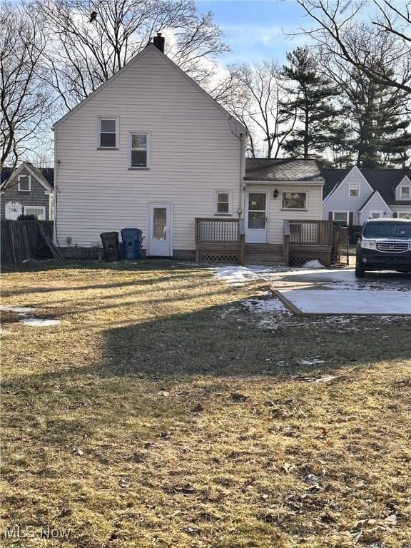 rear view of house with a wooden deck and a yard