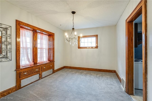 unfurnished dining area featuring carpet flooring and a notable chandelier