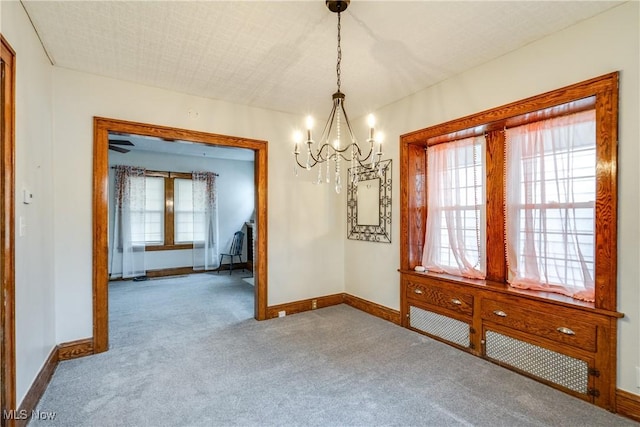 unfurnished dining area featuring carpet flooring and a chandelier