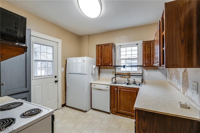 kitchen featuring sink, white appliances, and a textured ceiling