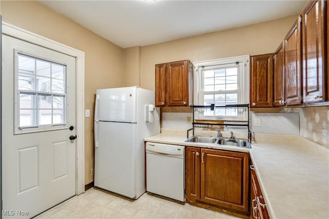 kitchen featuring white appliances and sink