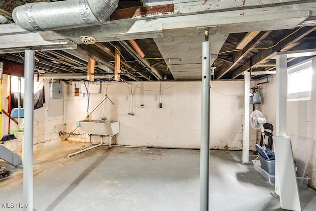 basement featuring electric panel and sink