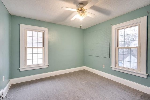 unfurnished room featuring carpet, a healthy amount of sunlight, a textured ceiling, and ceiling fan